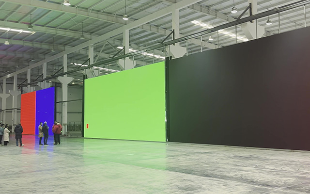 A warehouse space filled with LED surfaces showing solid colour