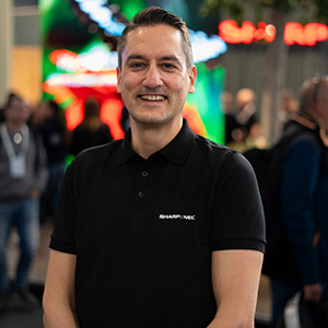 A man smiling, wearing a black t shirt
