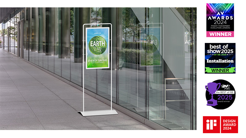 poster stand outside a glass-fronted building alongside numerous award logo